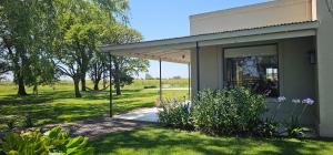 a small house with a porch and a garden at Casa de campo Don Juan in Duggan