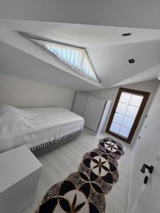 a attic bedroom with a bed and a window at Relax 1 Lüks villa in Kemer