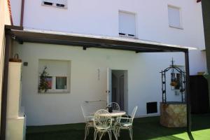 a patio with a table and chairs and a building at CasaLira in Castrillo de San Pelayo