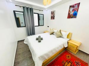a bedroom with a bed with a cross on it at Moonlight Surf Hostel in Taghazout