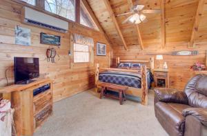 een slaapkamer met een bed en een tv in een hut bij Stunning views!Petfriendly22 with Pool table, Free tickets to Dollywood,Anakeesta,Aquarium &more in Sevierville