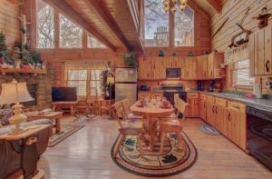 een keuken met houten kasten en een tafel in een huisje bij Stunning views!Petfriendly22 with Pool table, Free tickets to Dollywood,Anakeesta,Aquarium &more in Sevierville
