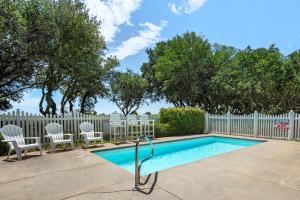 une piscine avec deux chaises et une clôture dans l'établissement Heaven On Seven, à Corolla