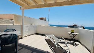 a balcony with chairs and a table and the ocean at Casa Charlotte El Cotillo in El Cotillo