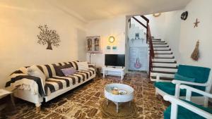 a living room with a couch and a stair case at Casa Charlotte El Cotillo in El Cotillo