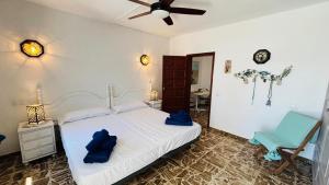 a bedroom with a white bed and a blue chair at Casa Charlotte El Cotillo in El Cotillo