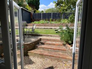 Una puerta abierta que conduce a un jardín con escaleras. en Cosy, Cute Annnex, en Sidmouth