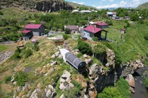 an aerial view of a train on a hill with houses at House by the River in Kʼaghsi