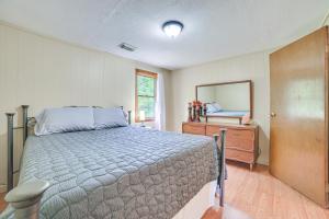 Un dormitorio con una cama, una cómoda y un espejo. en 16 Mi to Clear Lake State Park Secluded Cabin, en Atlanta