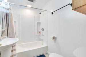 Un baño blanco con ducha y lavabo. en 16 Mi to Clear Lake State Park Secluded Cabin, en Atlanta 19 fotos más