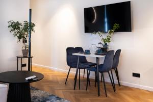 a dining room with a white table and blue chairs at Pinska Business Apartment in Päri