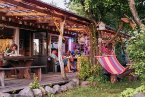 a porch of a restaurant with a hammock at Happy Hippy Cabin for 4 persons in Gataučiai