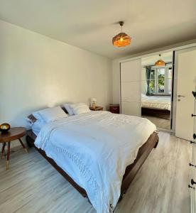 a bedroom with a large bed and a table at Tiny House avec terrasse privée, 10 mins du centre in Brussels