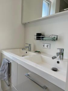 a white bathroom with a sink and a mirror at Tiny House avec terrasse privée, 10 mins du centre in Brussels