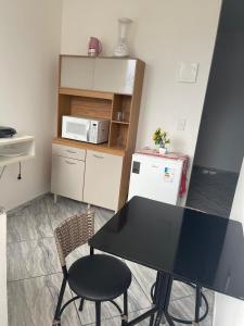 a small kitchen with a table and a microwave at Apartamento 5 km do Aeroporto in Brasilia