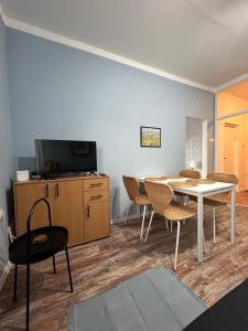 a living room with a table and chairs and a tv at Apartman Chilla 2 in Veliko Gradište