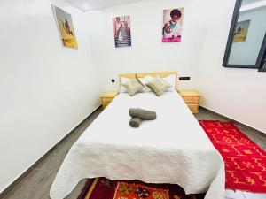 a bedroom with a white bed and a red rug at Moonlight Surf Hostel in Taghazout