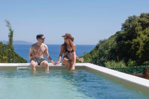 un homme et une femme assis dans une piscine dans l'établissement Divinum Mare Luxury Villa with Private Pool & Sea View just 200m from the Beach, à Palaiochórion 41 autres photos