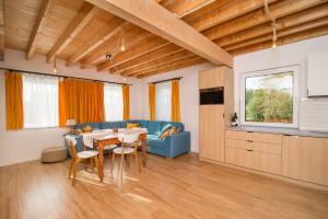 a living room with a table and a blue couch at Domek Bajkowy Zakątek nad jeziorem Narie in Bogaczewo