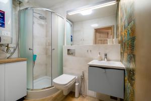 a bathroom with a toilet and a shower and a sink at Domek Bajkowy Zakątek nad jeziorem Narie in Bogaczewo +12 photos