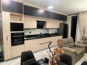 a living room with a couch and a kitchen at Mirador del Parque in Cochabamba