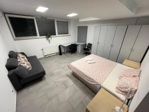 a bedroom with a bed and a desk and a couch at New Modern App in Ljubljana