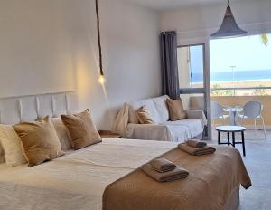 a bedroom with a large bed and a living room at Sun&Ocean in Morro del Jable