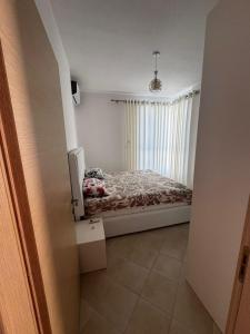 a bedroom with a bed in a room with a window at Paradise Apartment Radhime in Radhimë +6 photos