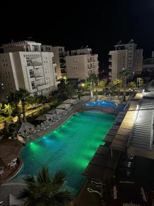 a large swimming pool with green lights at night at Paradise Apartment Radhime in Radhimë