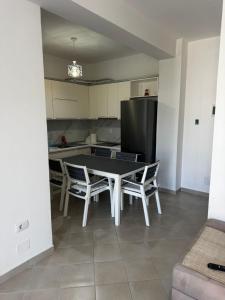 a kitchen with a table and chairs and a refrigerator at Paradise Apartment Radhime in Radhimë