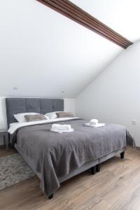 a bedroom with a large bed with two towels on it at Guest House ANA in Otočac