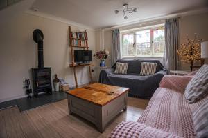 un salon avec un canapé et une table dans l'établissement Dreamy Suffolk Country Cottage Escape, à Aldeby