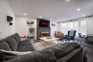 a living room with a couch and a table and a tv at Santa's Village Muskoka Retreat - Waterfront Kayaks Hot Tub in Bracebridge