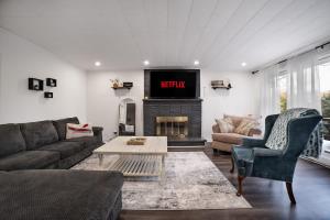 a living room with a couch and a tv at Santa's Village Muskoka Retreat - Waterfront Kayaks Hot Tub in Bracebridge