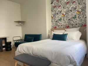 a bedroom with a large white bed and two chairs at Studio Calme Coeur Historique in Tours
