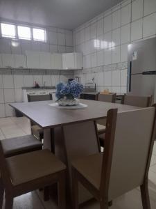 a kitchen with a table with a vase of flowers on it at Casa Dondoca 3 - City of Goiás in Goiás +3 photos