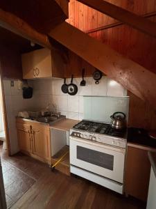 a kitchen with a white stove and a sink at Casas el Canelo in Isla Negra +4 photos