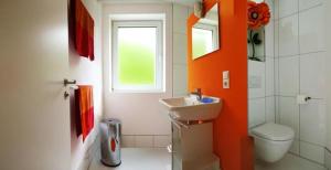 a bathroom with a sink and a toilet and a window at Indigo in Bullay