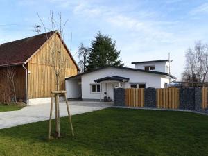 ein Haus mit einem Garten mit zwei Baseballschlägern im Gras in der Unterkunft Ferienwohnung am Weinberg in Ostrach