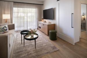 a living room with a couch and a tv at The Steward, Santa Barbara, a Tribute Portfolio Hotel in Santa Barbara