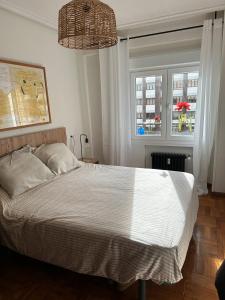 a bedroom with a large white bed with a window at Piso reformado centro de Oviedo in Oviedo