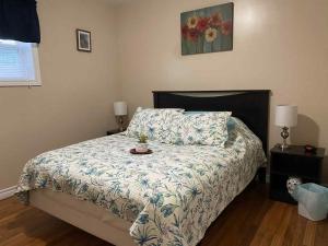 a bedroom with a bed with a comforter and a pillow at Down Home Accommodations in Rocky Harbour