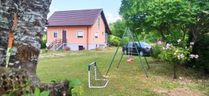 a yard with a swing set and a house at Holiday Home Vuković Plitvice Mountain Retreat in Saborsko +45 photos