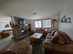 a living room with couches and a fireplace at Lumbermen's Village in Pinetop-Lakeside