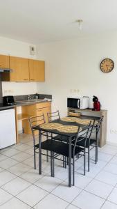 a kitchen with a table and chairs and a clock at Appartement 2 personnes sur Amiens in Amiens