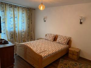 a bedroom with a bed and a table and a window at Maia Dorului in Mereteu