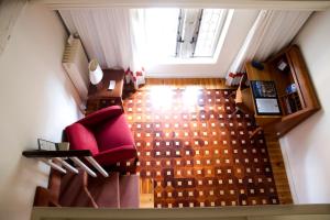 una vista aérea de una sala de estar con una silla roja en Hotel Posada Santa Maria la Real en Aguilar de Campóo