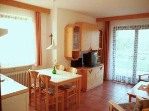 eine Küche und ein Esszimmer mit einem Tisch und Stühlen in der Unterkunft Ferienwohnungen Tröndle im Rosendorf in Weilheim