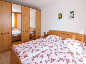 1 dormitorio con 1 cama grande con sábanas rojas y blancas en Ferienwohnungen Tröndle im Rosendorf, en Weilheim