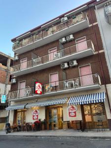 a building with tables and chairs in front of it at La Spagnola Affittacamere in Amantea